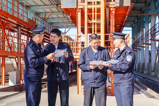 刑警支隊(duì)民警向企業(yè)職工發(fā)放宣傳資料并“一對(duì)一”講解電詐常識(shí)。謝仁古力·托呼提 攝